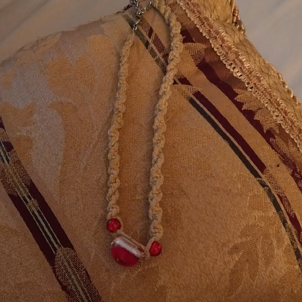 Knitted yarn necklace with red marbles